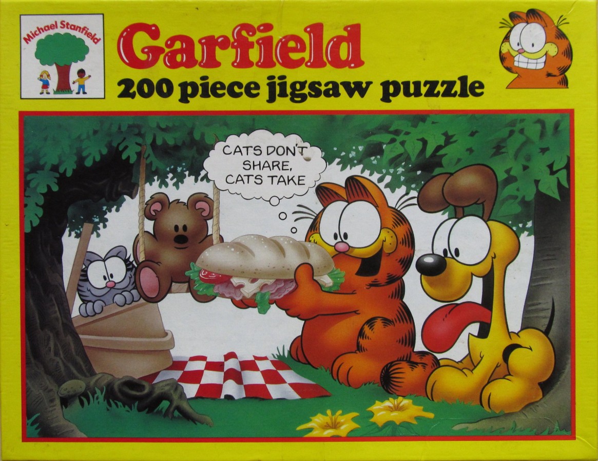 Garfield eating a sandwich while Odie and Pooky watch under a tree