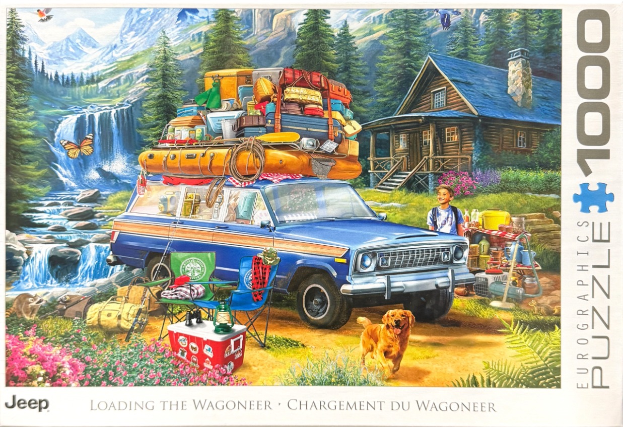 A blue Jeep Wagoneer packed with luggage, parked in a mountain campsite near a waterfall and cabin.