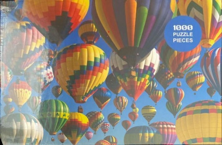 A low-angle view of dozens of colorful hot air balloons floating in a clear blue sky.