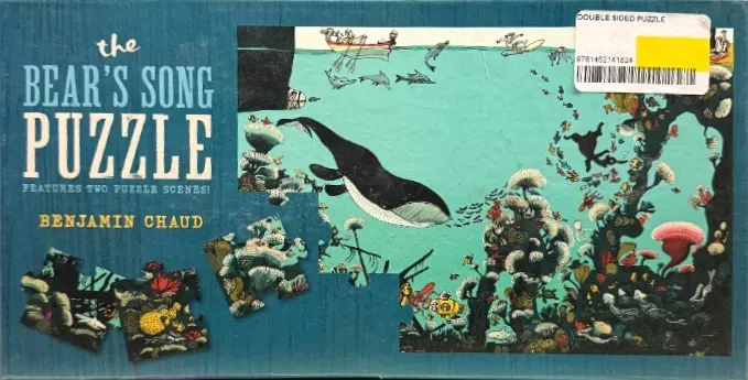Whimsical underwater scene with a large black whale and coral reefs in a flat, illustrative style.