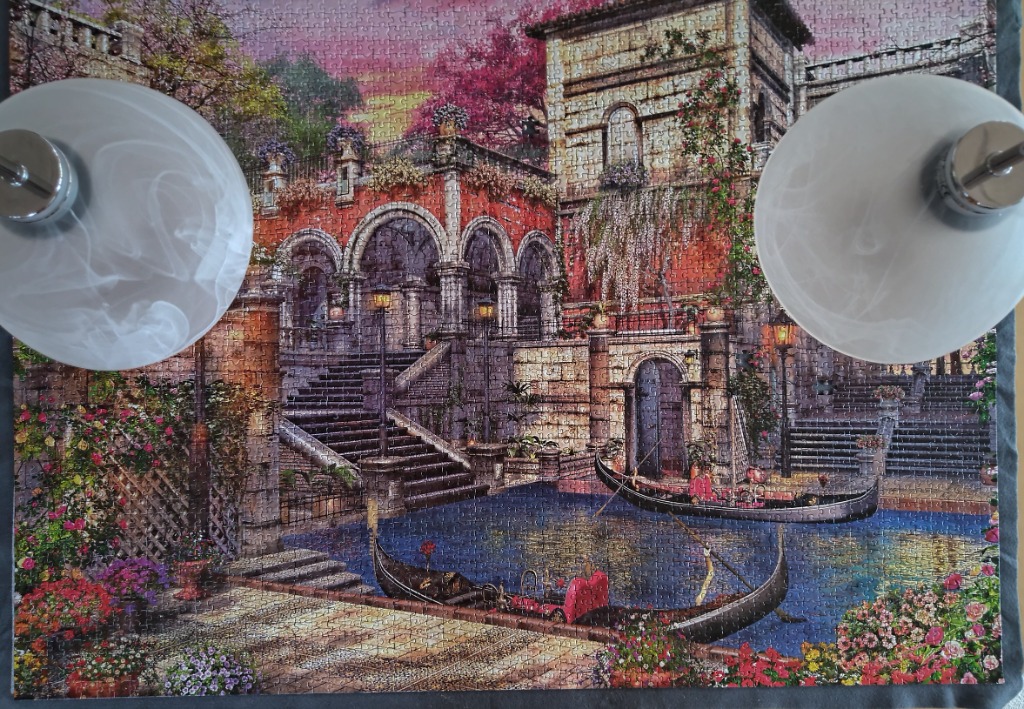Painting of a Venetian-style villa with gondolas on a canal at sunset.