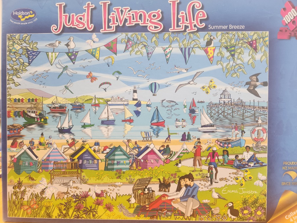 A colorful seaside illustration featuring beach huts, sailing boats, and people enjoying a sunny day by the coast.