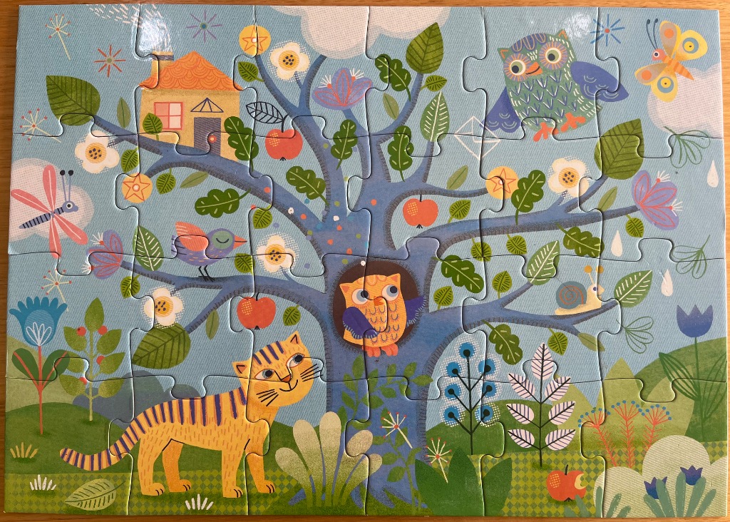 A whimsical illustration of a large blue tree filled with owls, a cat, and colorful forest life against a blue sky.