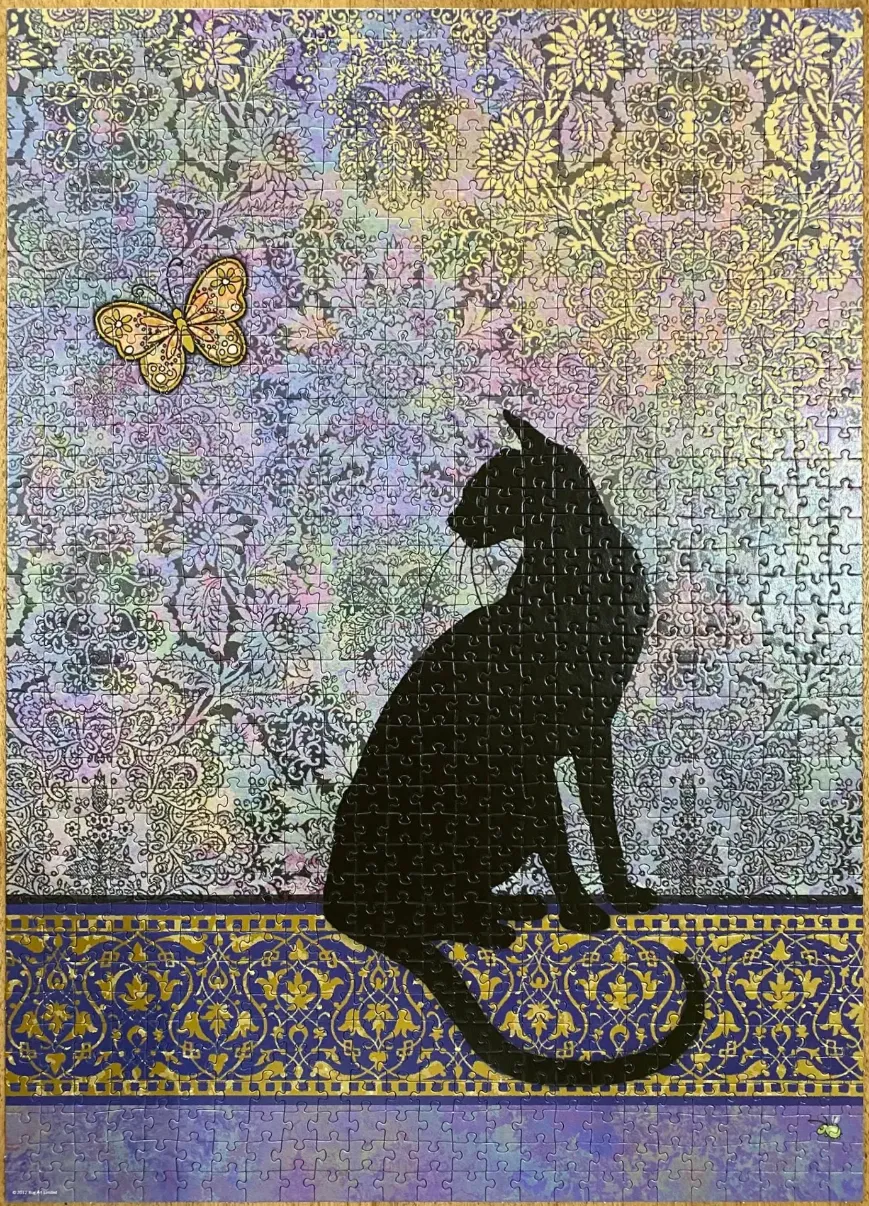 A black cat silhouette sits before a patterned floral background with a single butterfly.