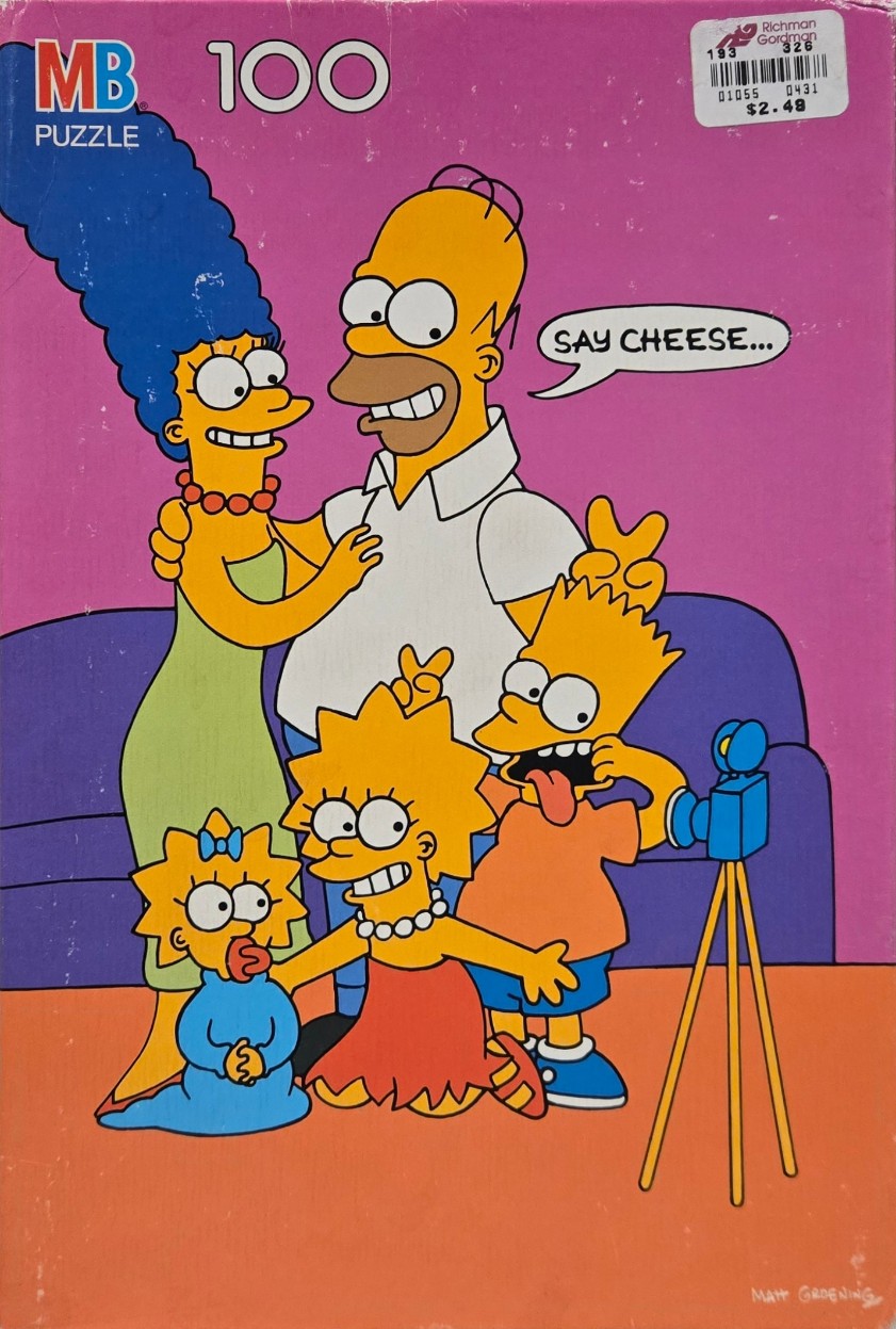 The Simpson family posing for a photo with Homer saying Say Cheese