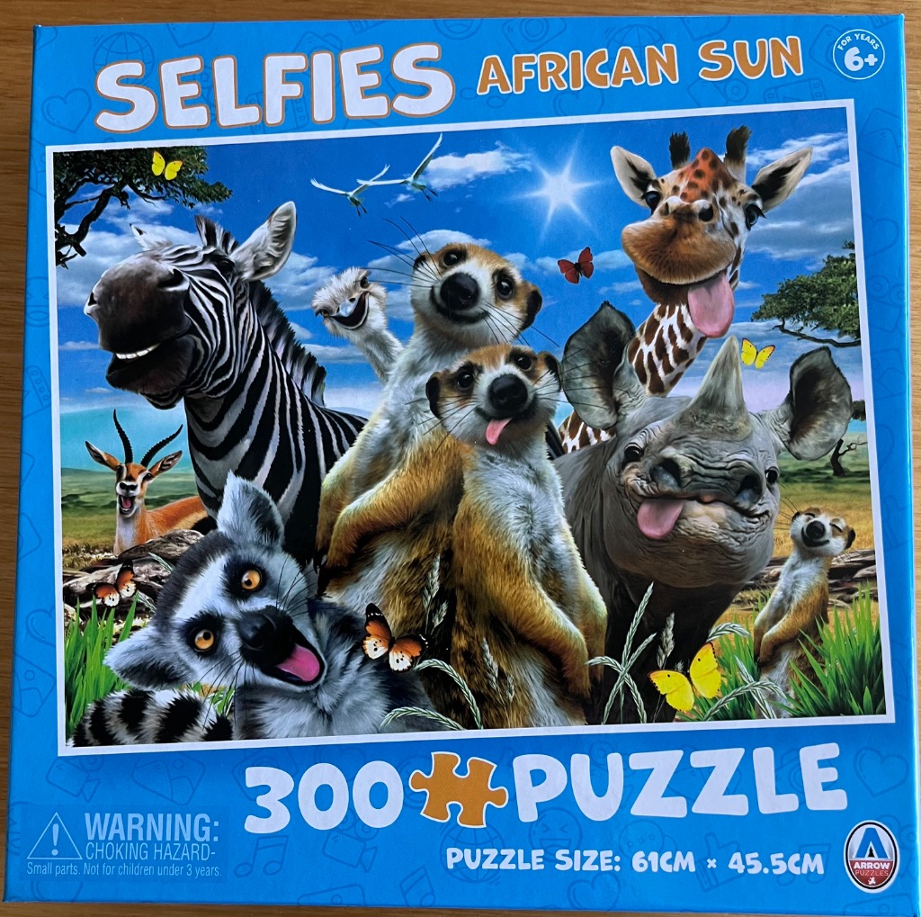 A whimsical collection of African animals posing together for a selfie against a bright blue sky.