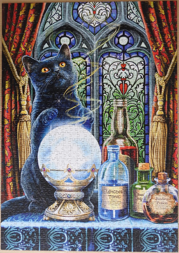 A black cat with orange eyes looking into a glowing crystal ball in front of a stained-glass window.