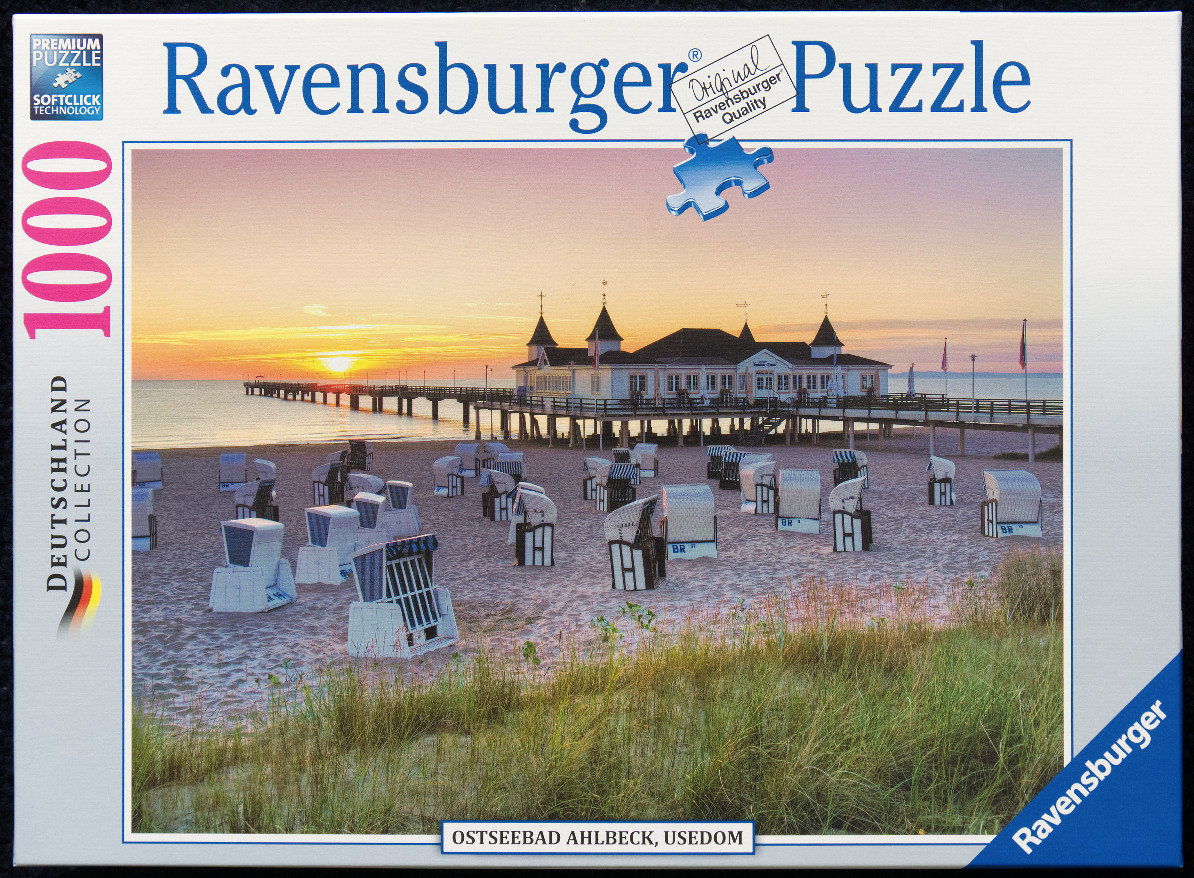A photograph of the Ahlbeck pier on the island of Usedom at sunset with beach baskets on the sand.