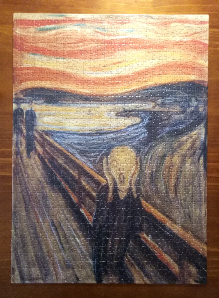 A print of The Scream, an iconic expressionist painting featuring a distressed figure on a bridge under a fiery sky.