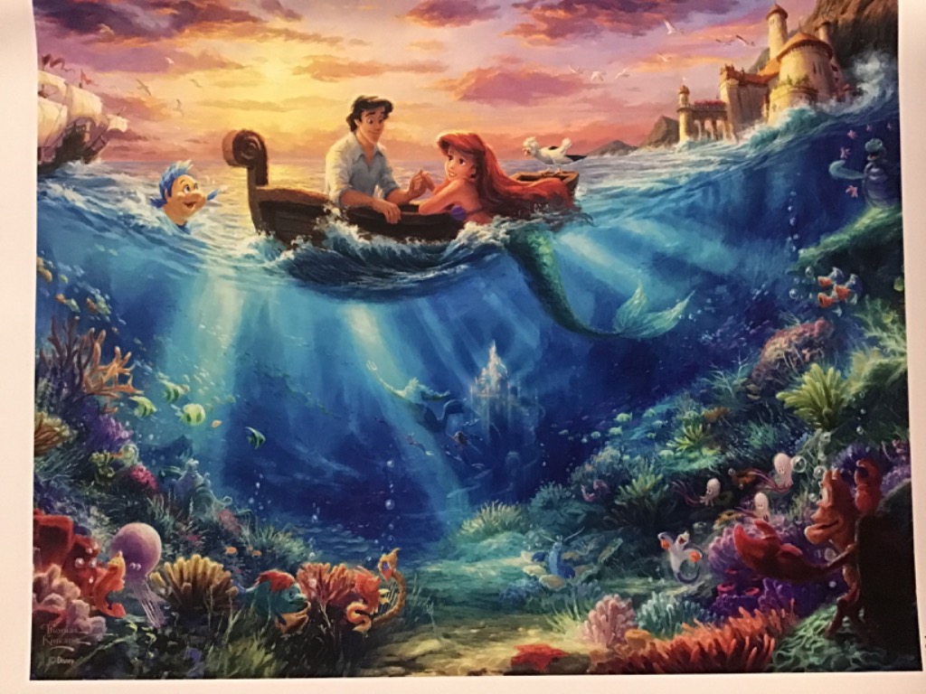 A young woman with long red hair and a man sit in a rowboat at sunset, with a vibrant underwater scene below them.