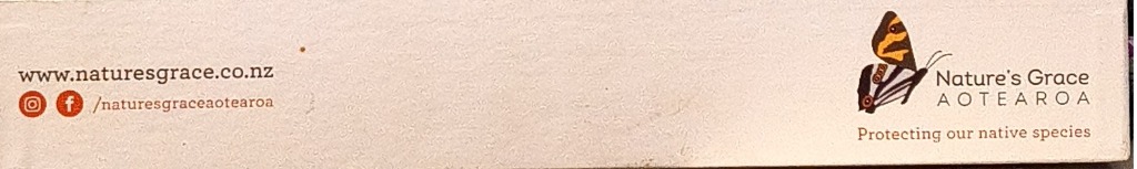 A close-up of a product edge featuring a small butterfly illustration and text on a light beige background.