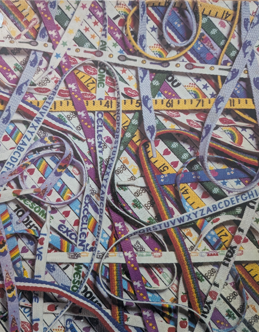 A chaotic, overlapping pile of colorful fabric shoelaces featuring various patterns, letters, and designs.