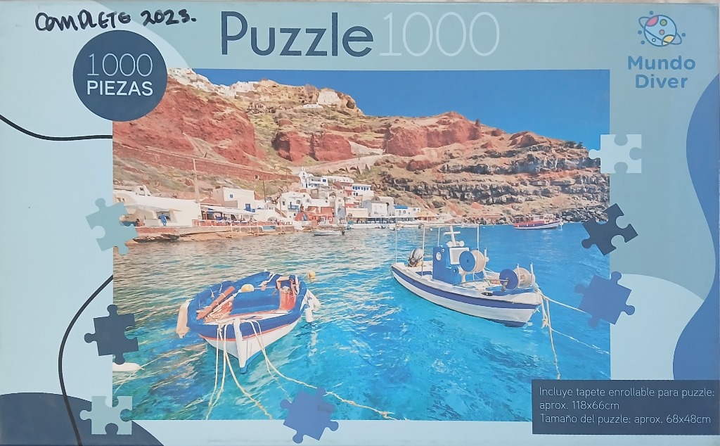 Scenic view of a Greek harbor with blue and white boats against a rocky hillside and deep blue sea.