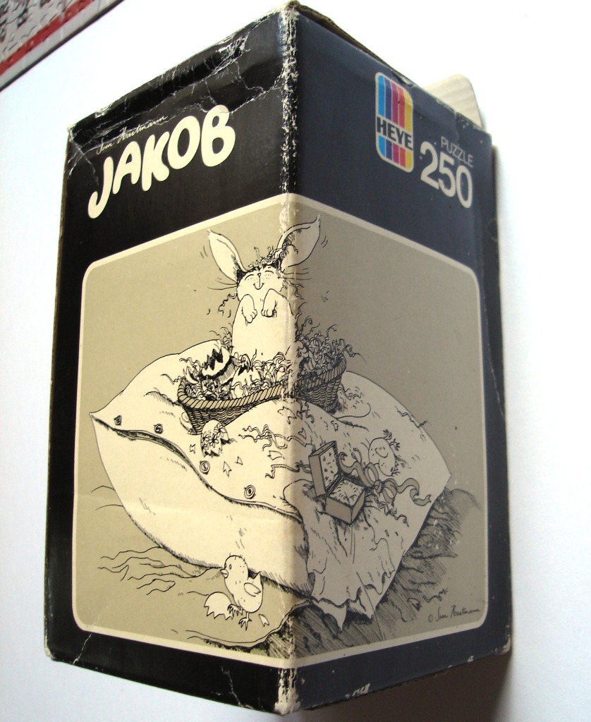 Line drawing of a rabbit sitting on a large pillow with eggs and a chick, in a black and beige frame.