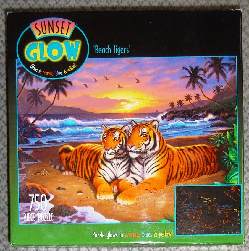 Two tigers resting on a tropical beach at sunset