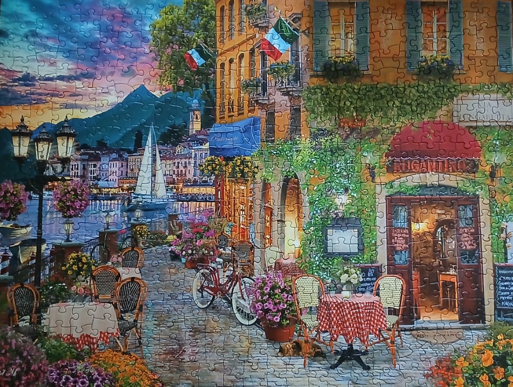 A romantic Italian lakeside cafe scene at dusk.