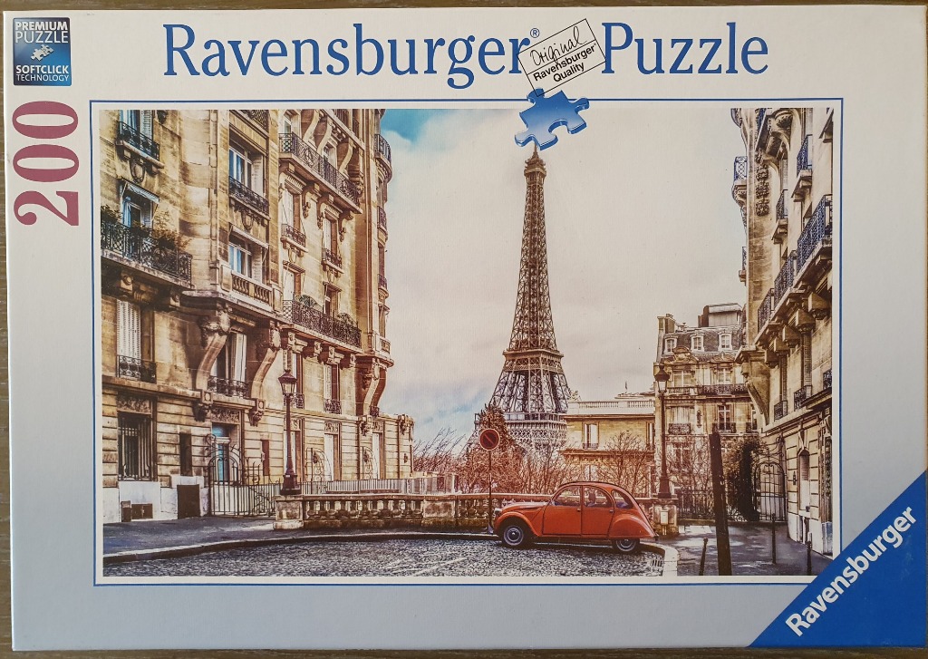 A classic Paris street scene with the Eiffel Tower in the distance and a vintage orange car in the foreground.