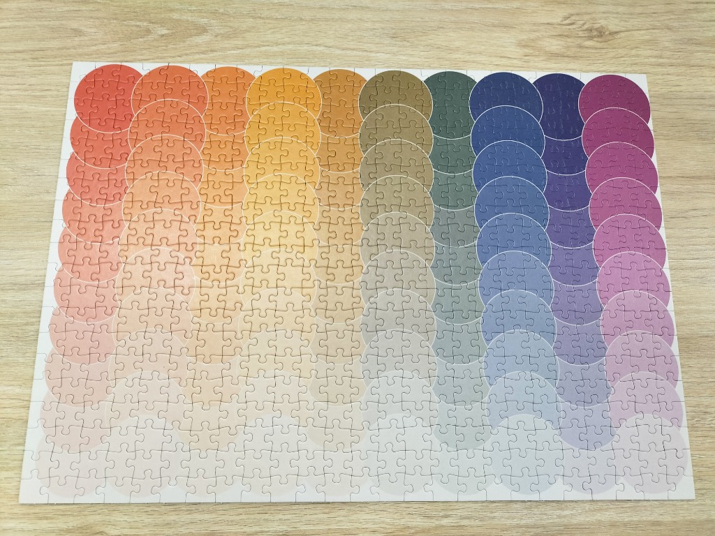 A grid of overlapping circles in a spectrum of colors ranging from warm orange on the left to cool purple on the right.