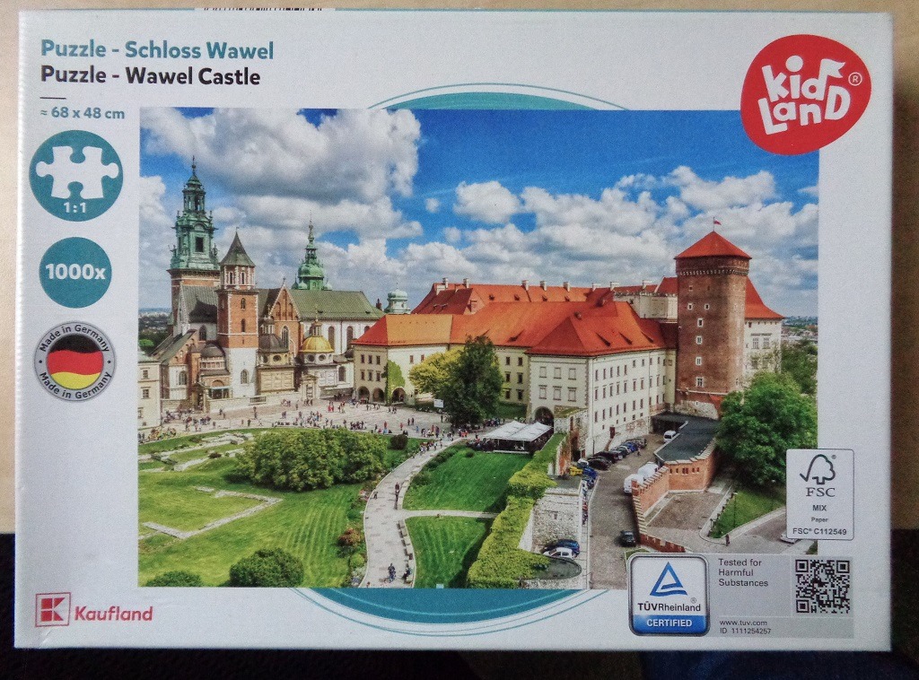 A sunny, high-angle photograph of Wawel Castle in Krakow, Poland, featuring its historic towers and courtyard.