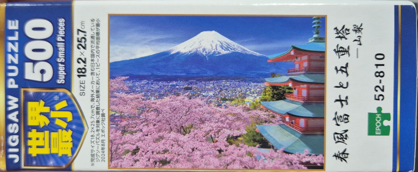Mount Fuji, pagoda, and pink cherry blossoms under a blue sky.