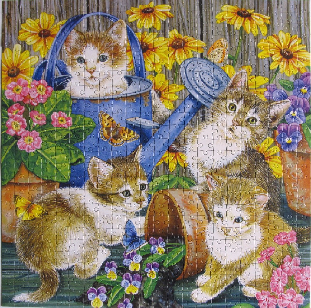 Four kittens playing with a blue watering can and potted flowers in a garden setting.