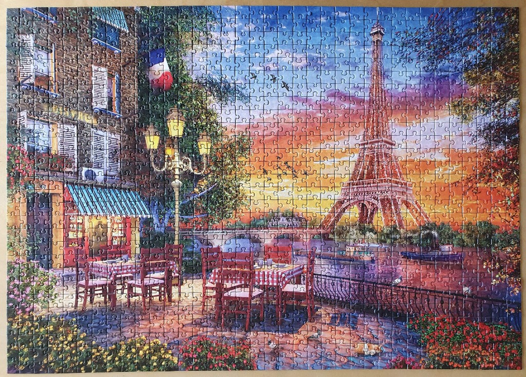 A romantic outdoor cafe scene in Paris at sunset with the Eiffel Tower in the background.