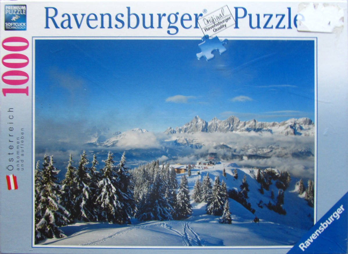 A scenic photograph of snow-covered mountains in Austria with evergreen trees in the foreground.
