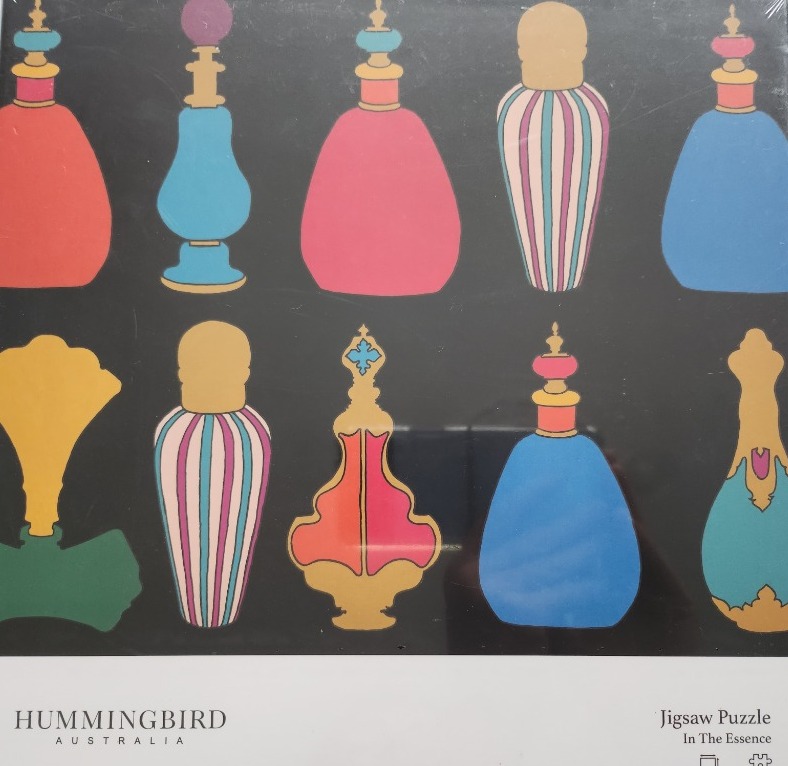 A collection of ten decorative vintage perfume bottles arranged in two rows against a solid black background.