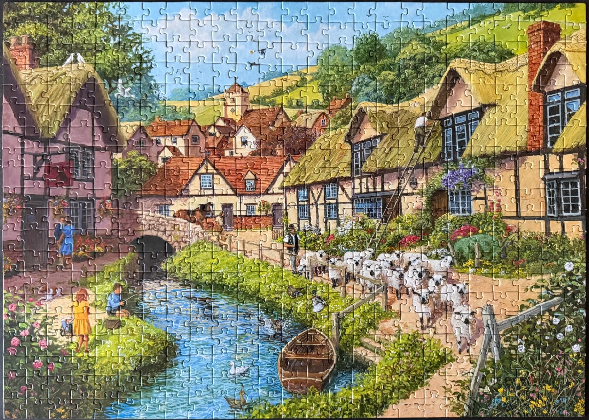 A peaceful English countryside scene with a thatched-roof village, a stream, and a flock of sheep.