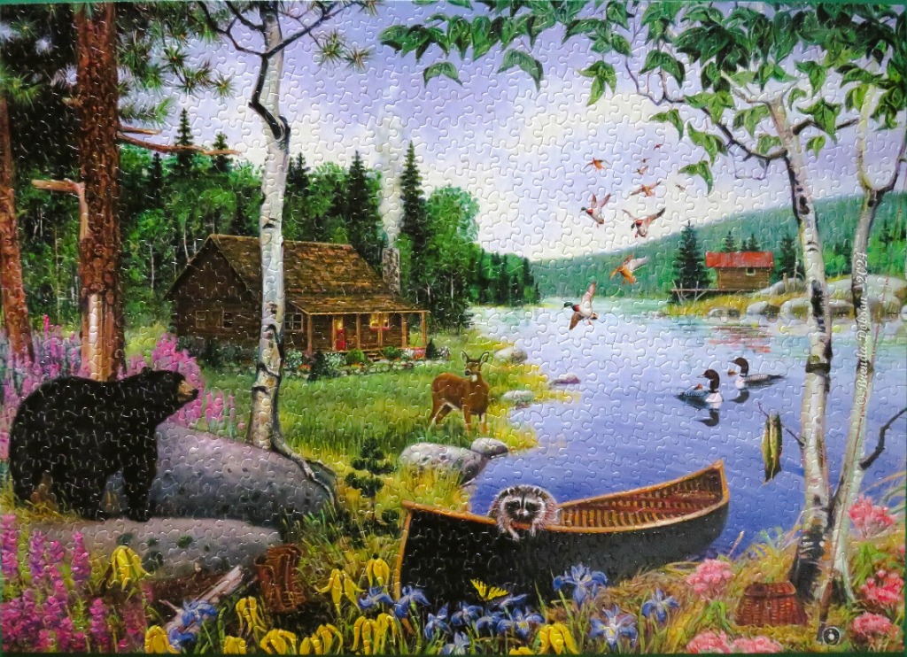 A peaceful lakeside scene featuring a log cabin, a black bear, a canoe, and various wildlife in a forest setting.