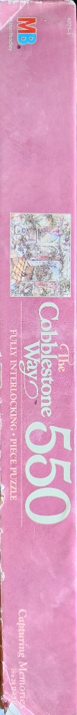 Pink box with a detailed cottage scene and "The Cobblestone Way" text.