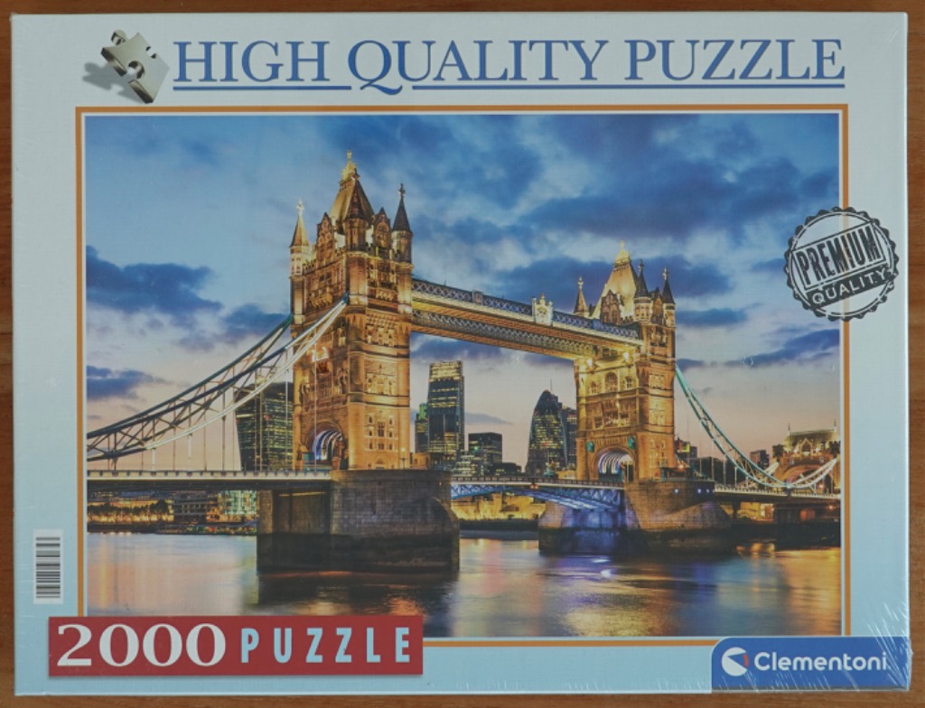 Photograph of London's Tower Bridge illuminated at dusk with a modern city skyline in the background.