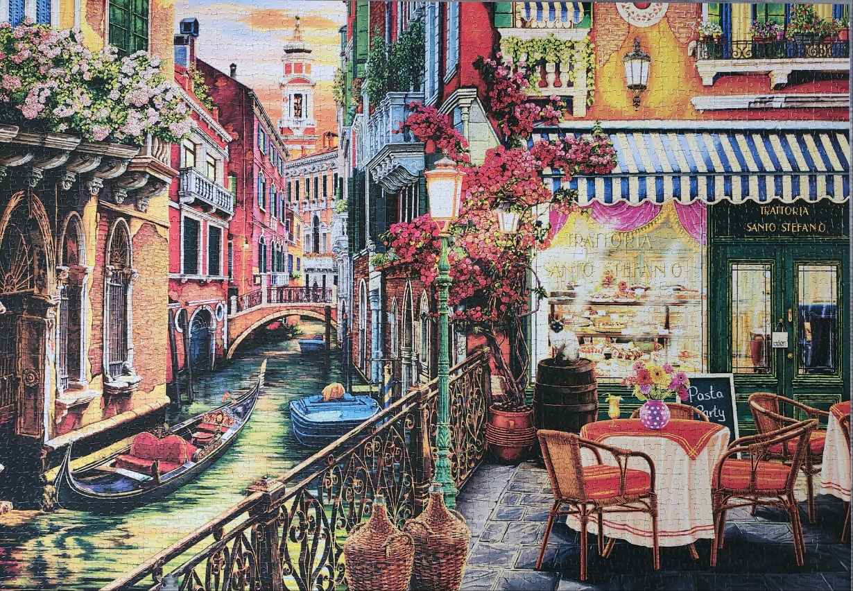 A charming Venetian canal scene with a trattoria patio, gondolas, and vibrant flowers at sunset.