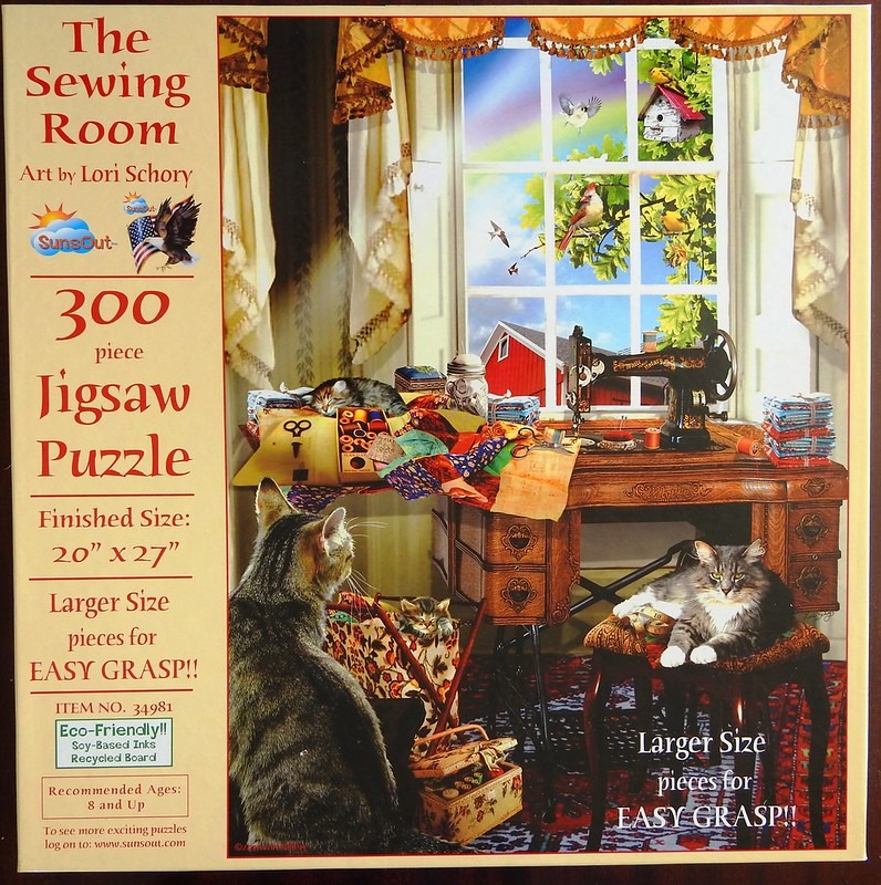 A sewing room scene with an antique sewing machine, assorted fabric scraps, and three cats in a sunlit room.