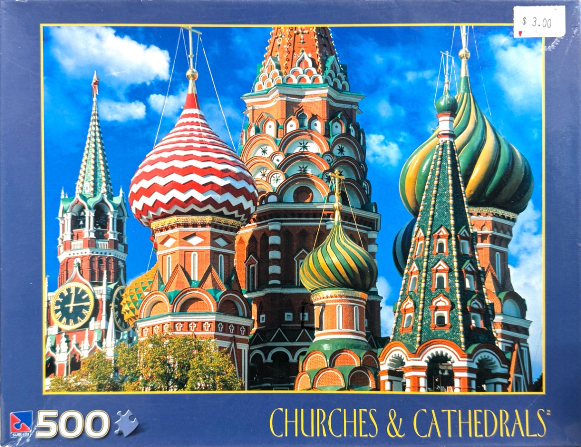 Colorful domes and spires of Saint Basil's Cathedral under a bright blue sky.