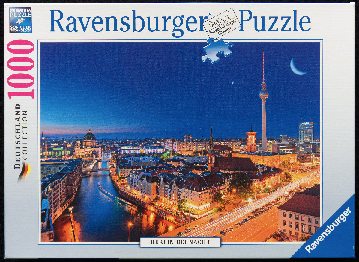 A panoramic night-time photograph of the Berlin skyline at dusk featuring the TV Tower and River Spree.