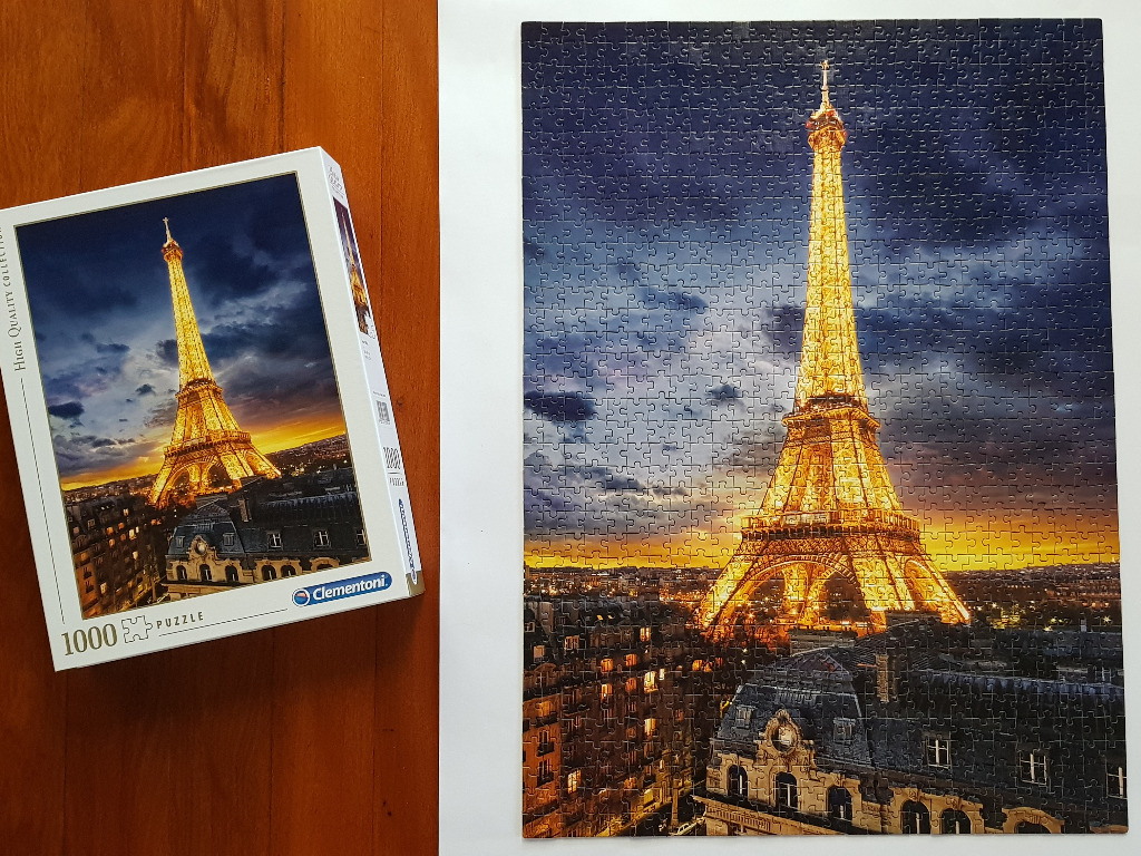 A twilight view of the Eiffel Tower illuminated in gold against a sunset sky.