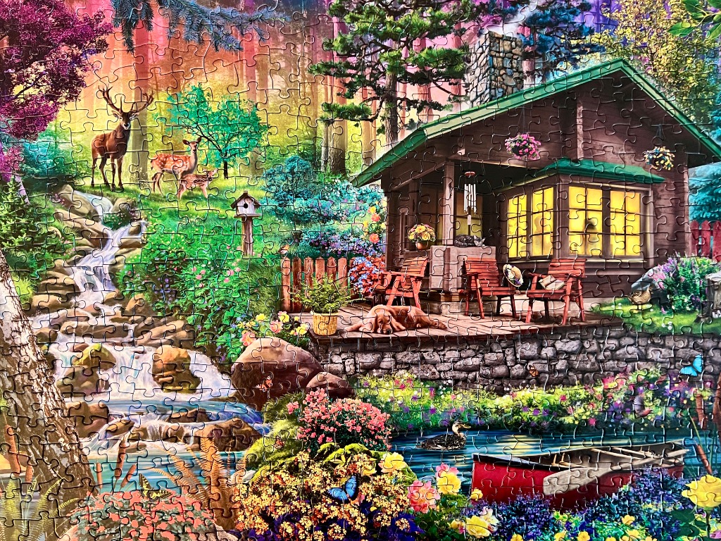 A cozy rustic cabin scene featuring a deer family, a waterfall, and a pond in a vibrant, sunlit forest.