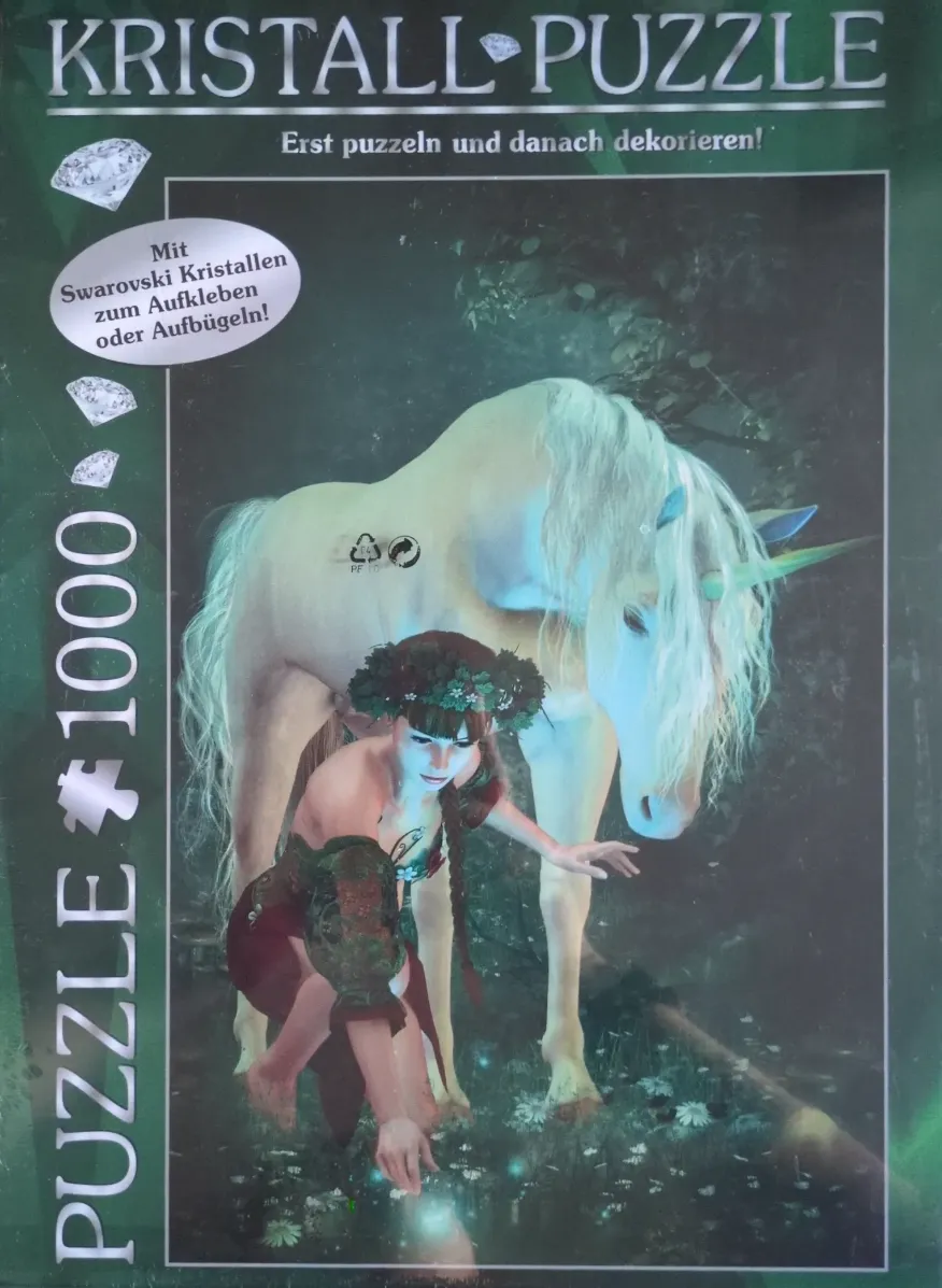 A woman in a floral crown crouching next to a glowing white unicorn in a dark forest.