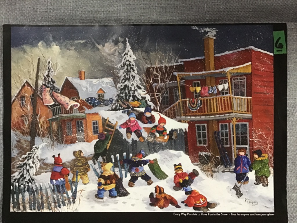 A group of children playing in the snow around colorful houses at night