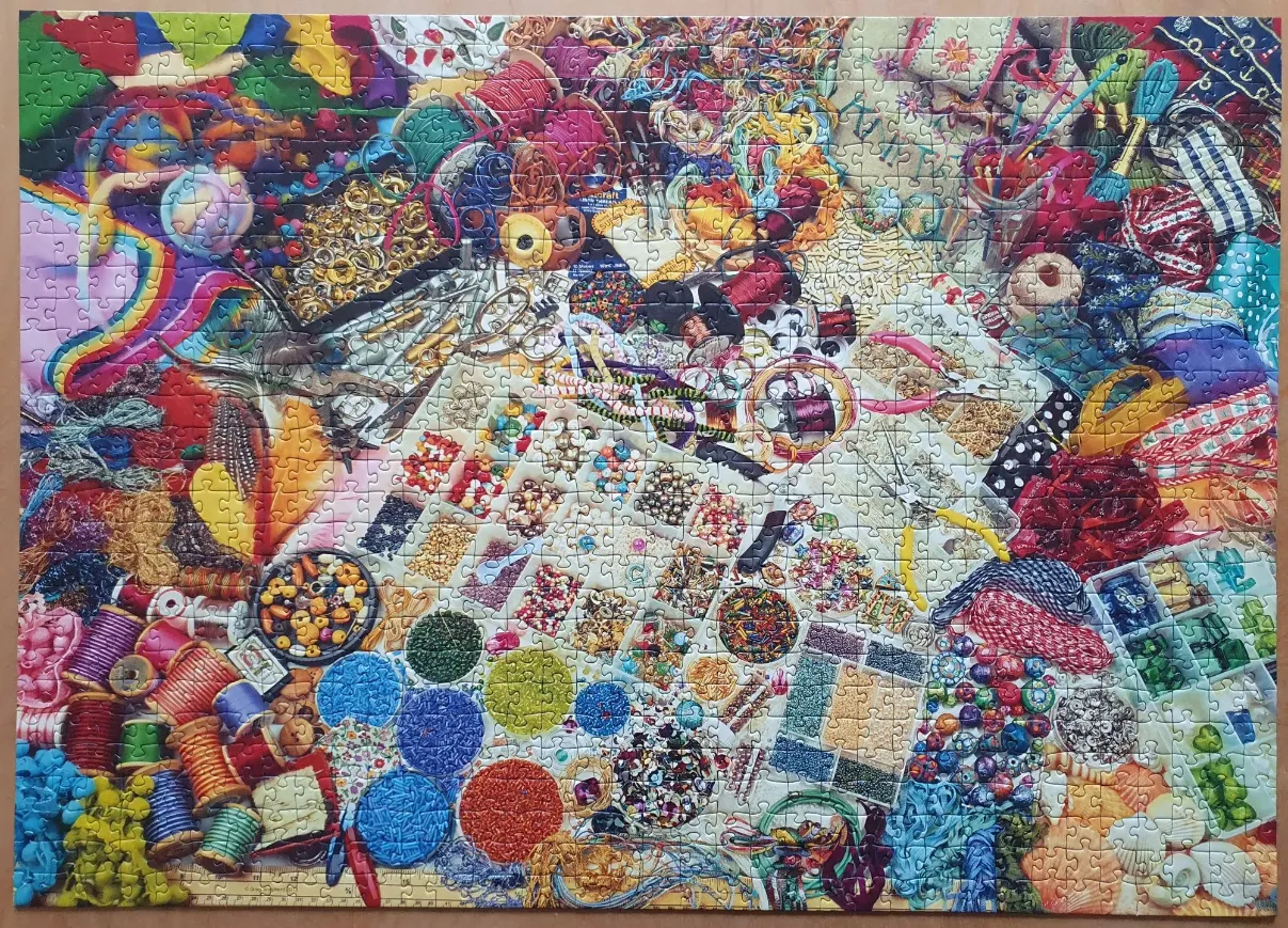 A vibrant, overhead-view collage of crafting supplies, including beads, thread, ribbons, and jewelry tools.
