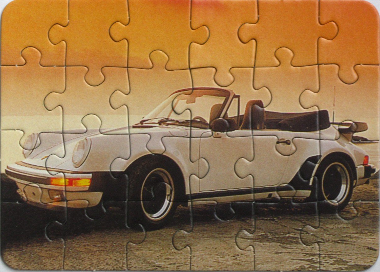 A white vintage convertible sports car parked at sunset by the water.