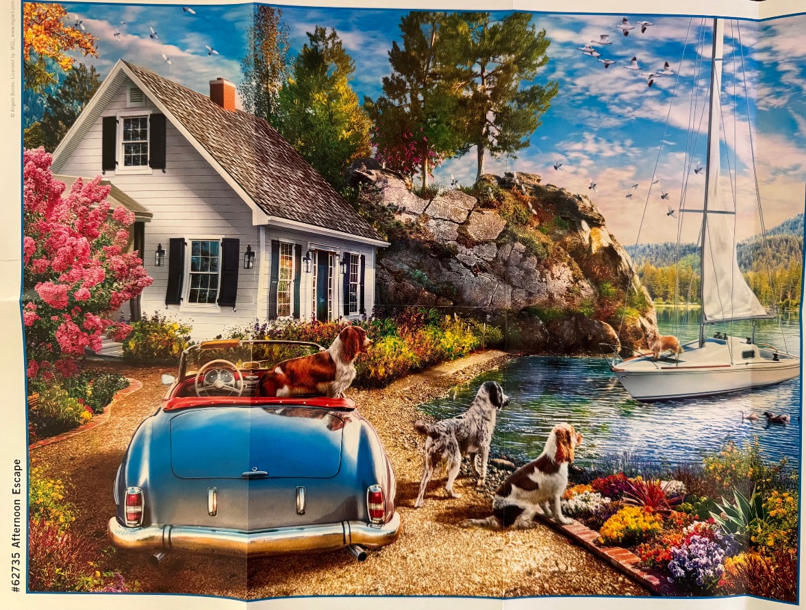 A blue convertible parked by a cottage and sailboat with three dogs in a sunny, flower-filled coastal setting.