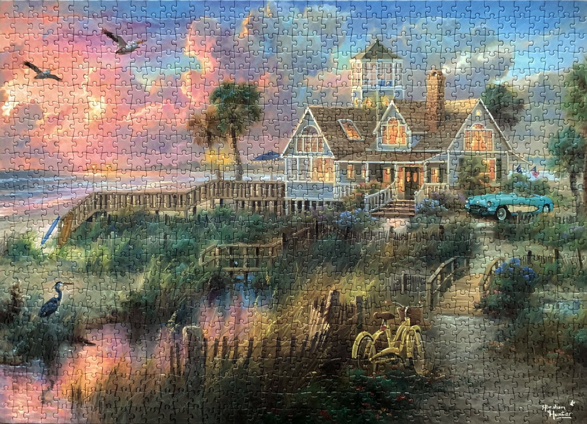 A cozy coastal cottage at sunset with a vintage blue car, a yellow bicycle, and birds flying over the ocean.
