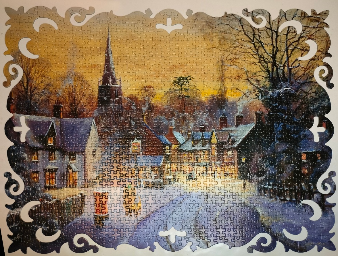 A wintry English village scene at twilight framed by an ornate white border.