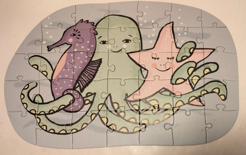 Whimsical illustration of a purple seahorse, a green octopus, and a pink starfish against a grey background.