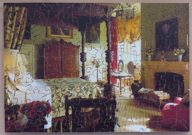 An opulent, traditional-style bedroom featuring a large four-poster bed and period furniture.