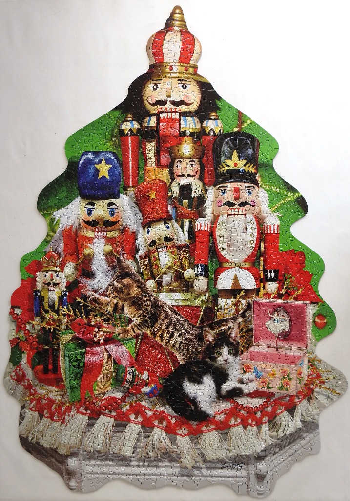 A Christmas-tree-shaped illustration of nutcracker soldiers, kittens, and gifts.