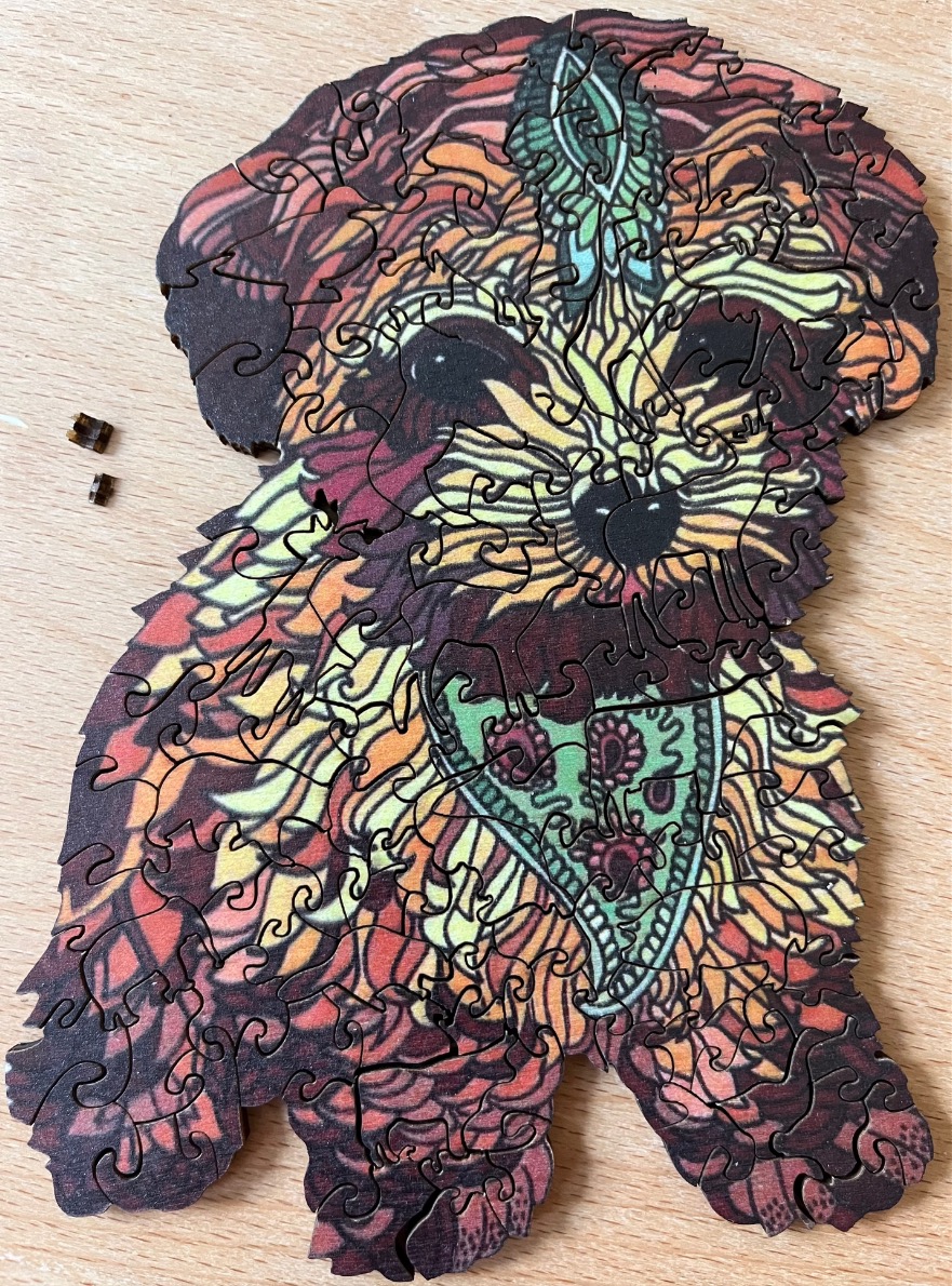 Stylized illustration of a dog with intricate paisley and floral patterns in warm tones.