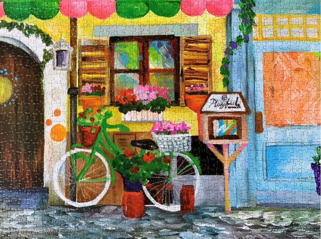 Painting of a quaint yellow storefront with a green bicycle, flower boxes, and a small sign.